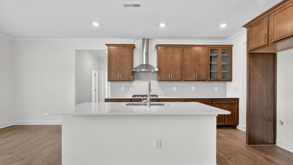 kitchen with brown cabinets quartz countertops and stainless steel appliances