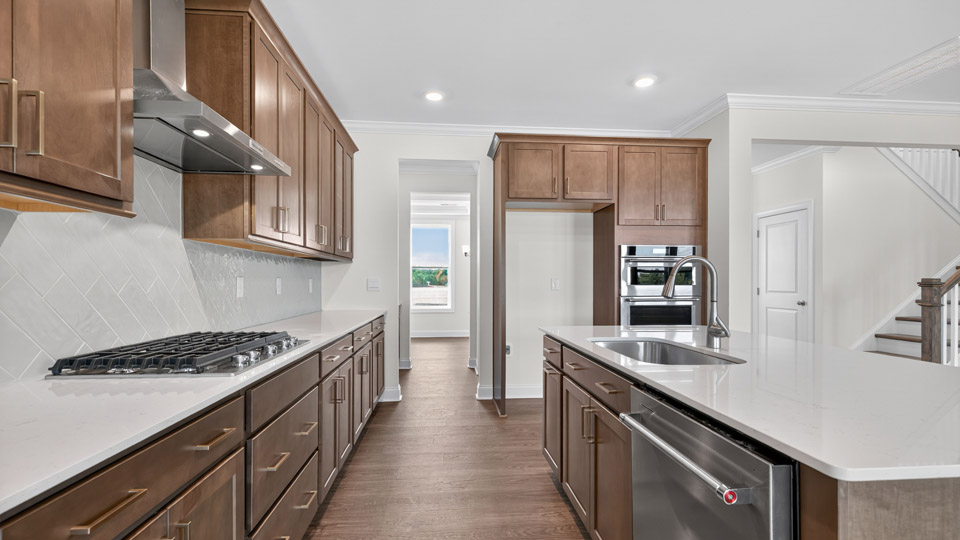 kitchen with brown cabinets quartz countertops and stainless steel appliances