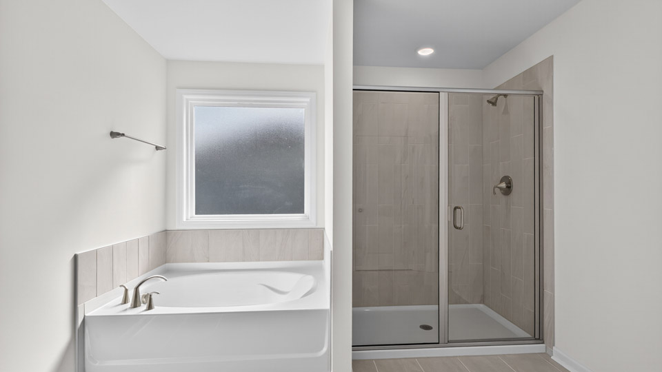 bathroom with separate tub and walk-in shower and window above tub