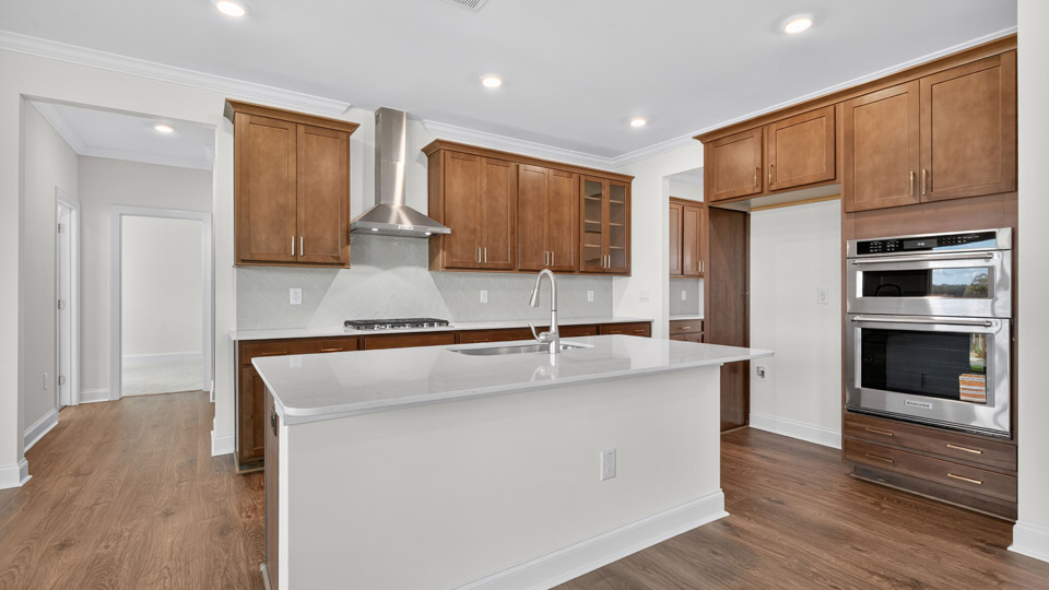 kitchen with brown cabinets quartz countertops and revwood flooring