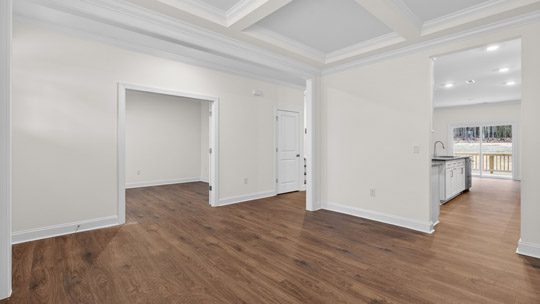 dining room with coffered ceiling and revwood flooring