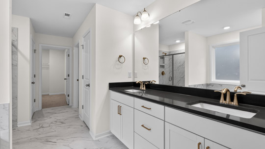 primary bathroom with white cabinets and quartz countertops and dual vanity
