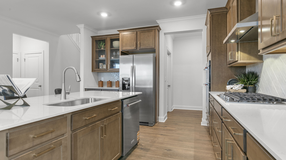 kitchen with quartz counters, kitchen island, pantry, stainless steel appliances