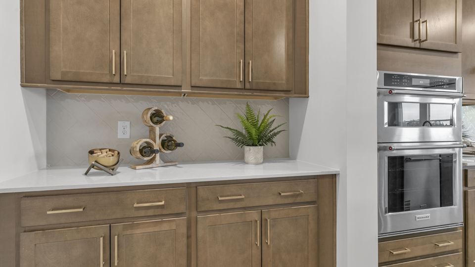 kitchen with quartz counters, kitchen island, pantry, stainless steel appliances