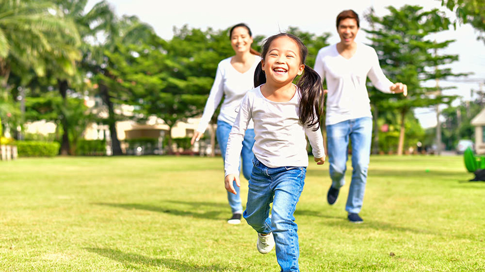 young couple chasing daughter outside