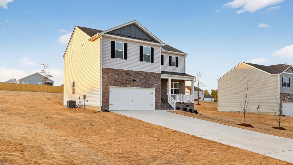Two story home with white colored siding with a two car garage