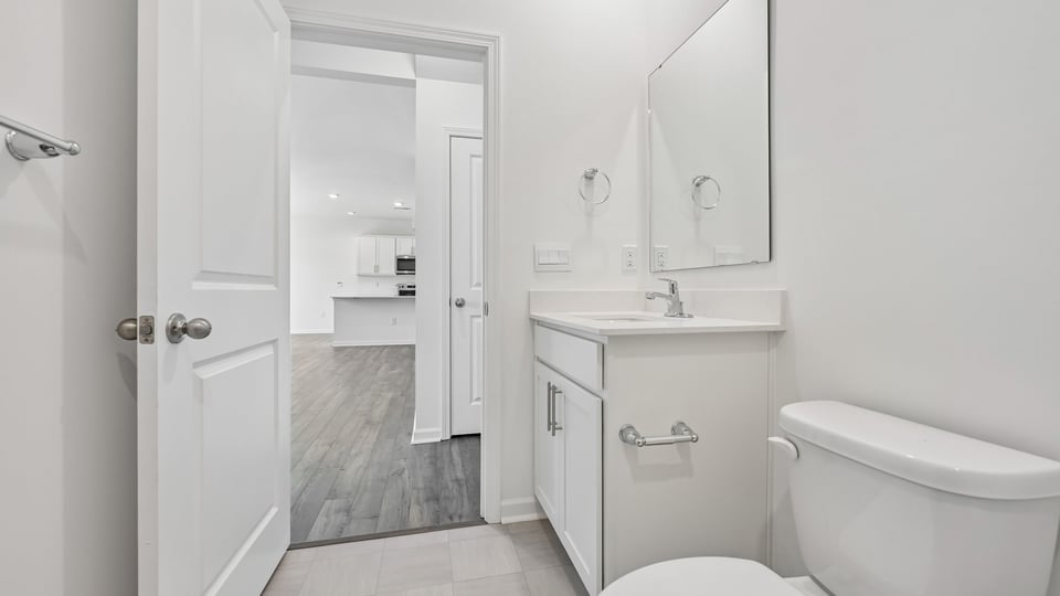 bathroom with white cabinets and quartz countertops