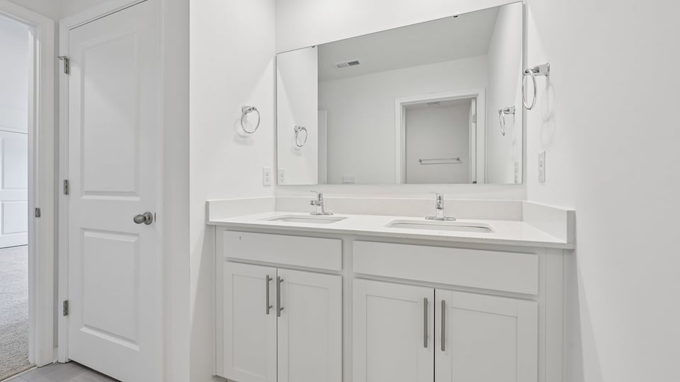 bathroom with dual vanity white cabinets and quartz countertops