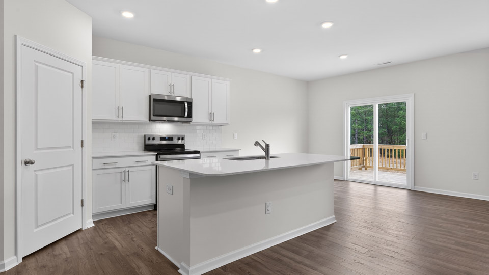 kitchen with quartz counters, kitchen island, pantry, stainless steel appliances