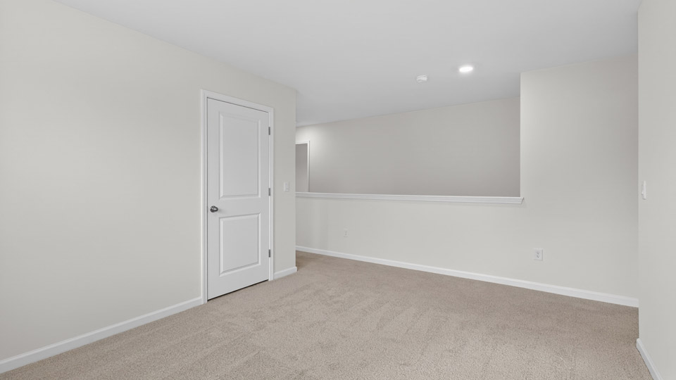 upstairs loft area with large windows and carpeting