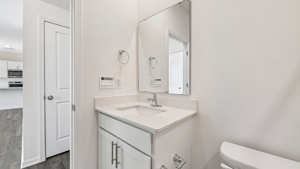 bathroom with white cabinets and quartz countertops