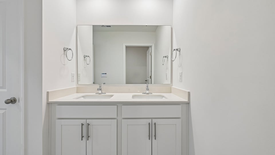 bathroom with dual vanity and quartz countertops