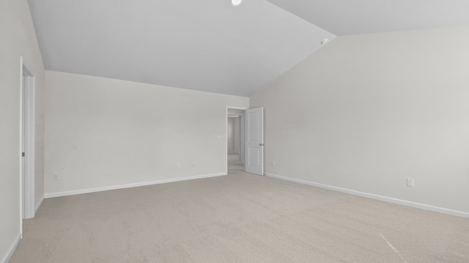 primary bedroom with two windows and carpeting, attached bath