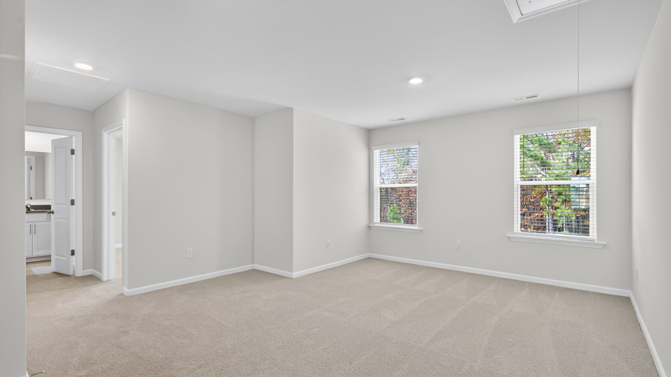 upstairs loft area with large windows and carpeting