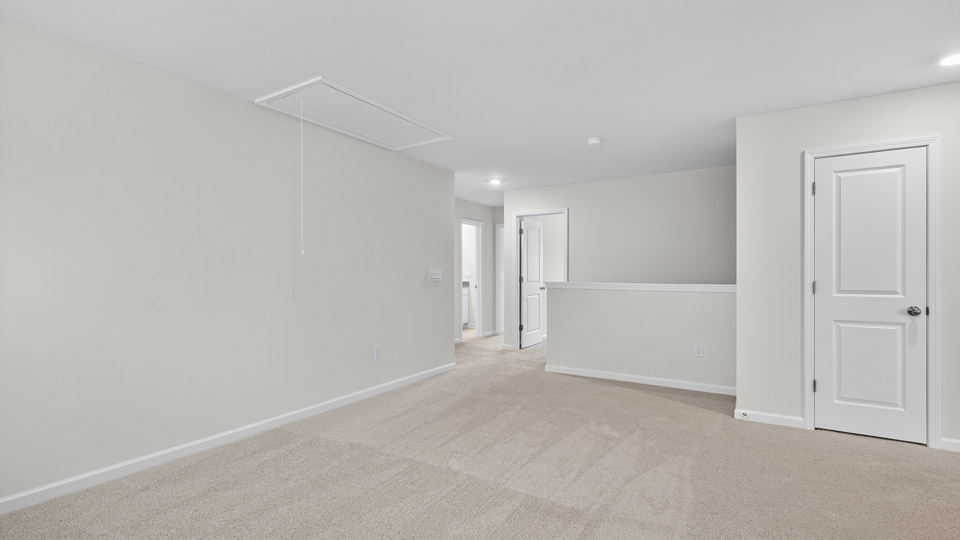 upstairs loft area with large windows and carpeting
