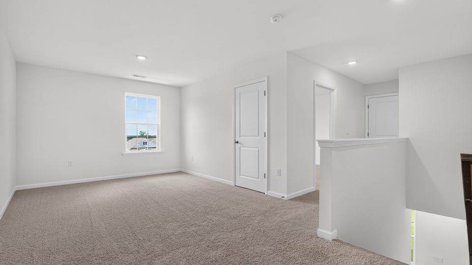upstairs loft area with large windows and carpeting