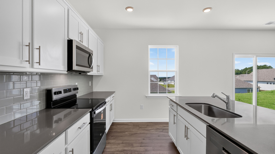 kitchen with quartz counters, kitchen island, pantry, stainless steel appliances