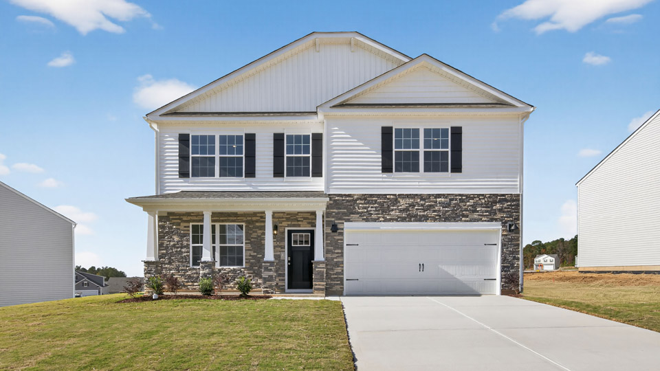 Two story home with white siding and two-car garage.