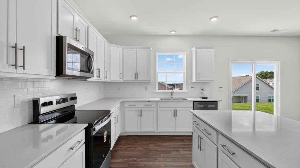 kitchen with quartz counters, kitchen island, pantry, stainless steel appliances