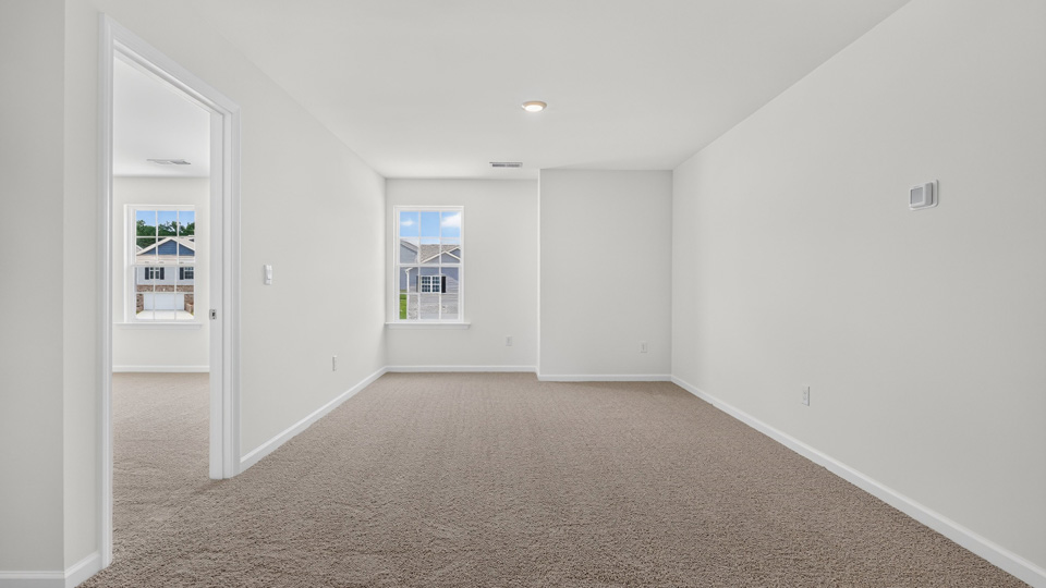 upstairs loft area with large windows and carpeting