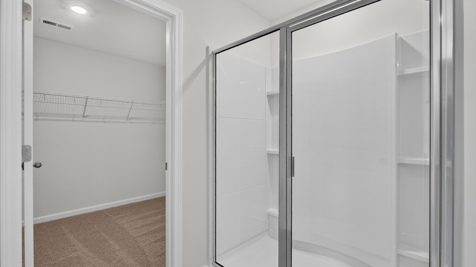 primary bathroom with walk in shower and dual vanity sinks