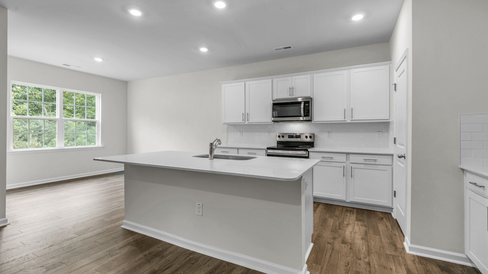 kitchen with quartz counters, kitchen island, pantry, stainless steel appliances
