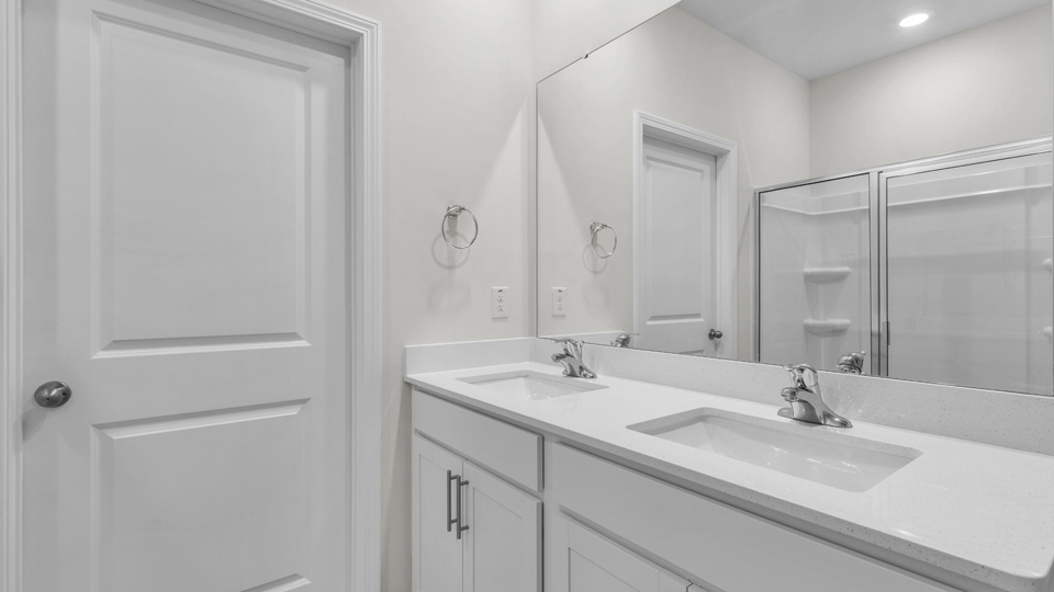 primary bathroom with walk in shower and dual vanity sinks