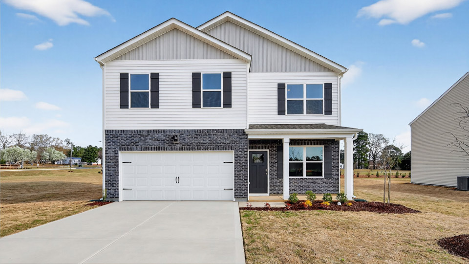 Two story home with white colored siding with a two car garage