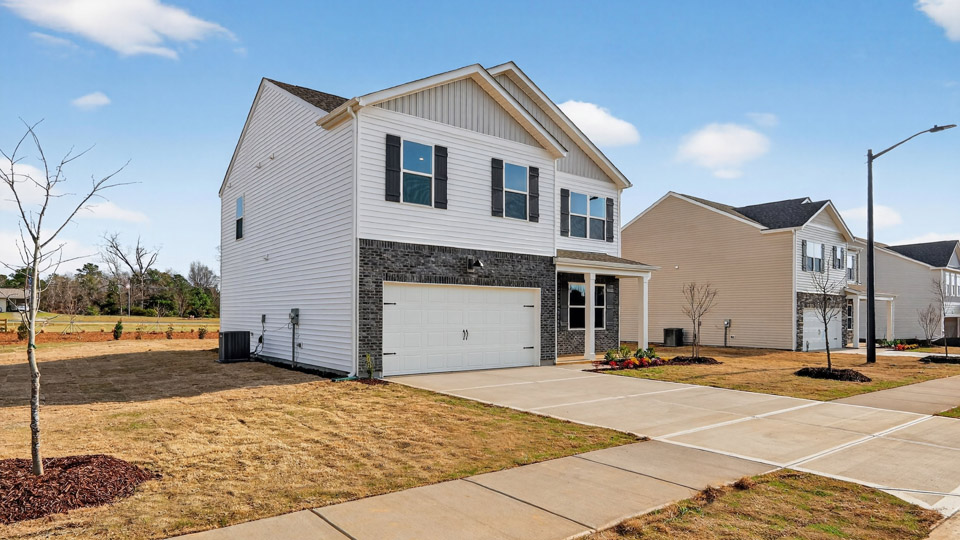 Two story home with white colored siding with a two car garage