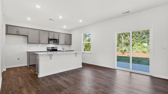 kitchen with island quartz countertops and sliding glass doors to patio