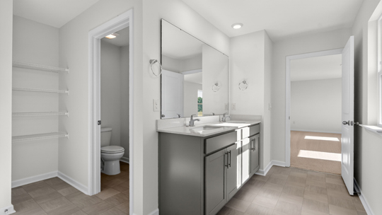 bathroom with gray cabinets and quartz countertops