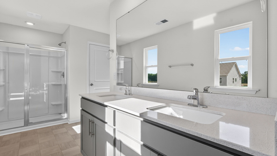 bathroom with dual vanity and walkin glass door shower