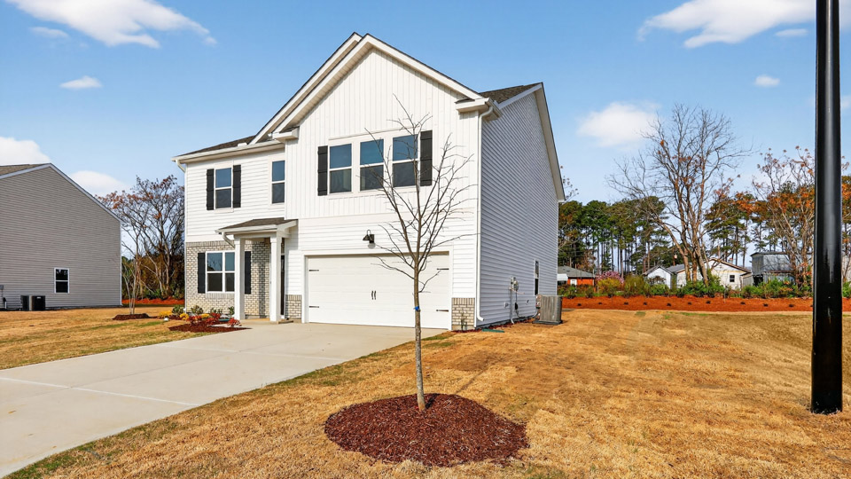 Two story home with white colored siding with a two car garage
