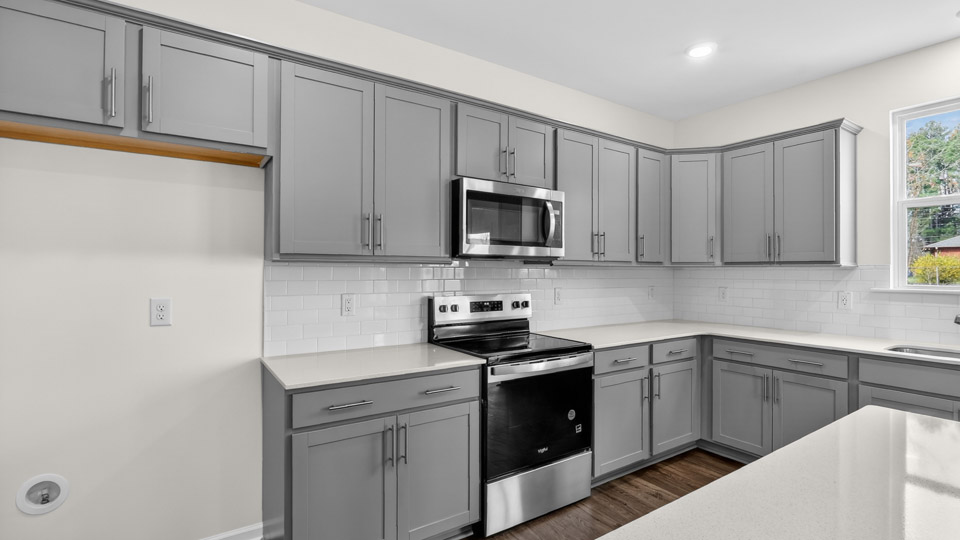 Kitchen with gray cabinets and stainless steel appliances.