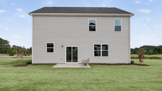 back of home with concrete patio