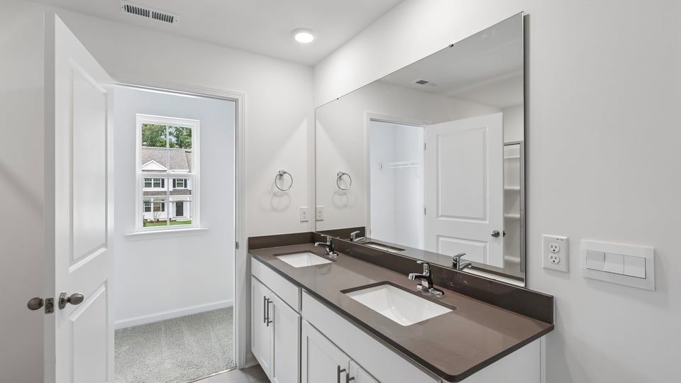 bathroom with dual sinks and quartz countertops