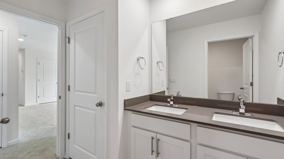 bathroom with dual sinks and quartz countertops