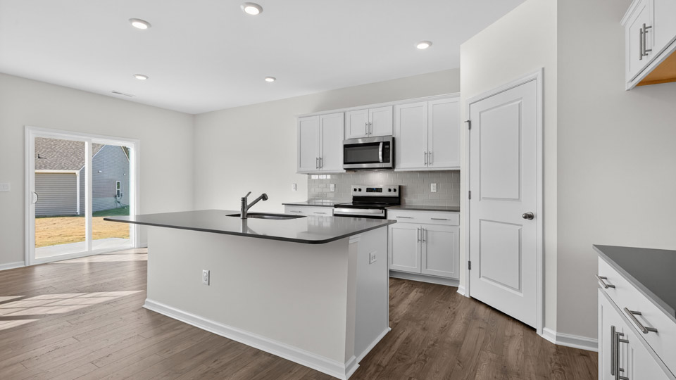 kitchen with quartz counters, kitchen island, pantry, stainless steel appliances
