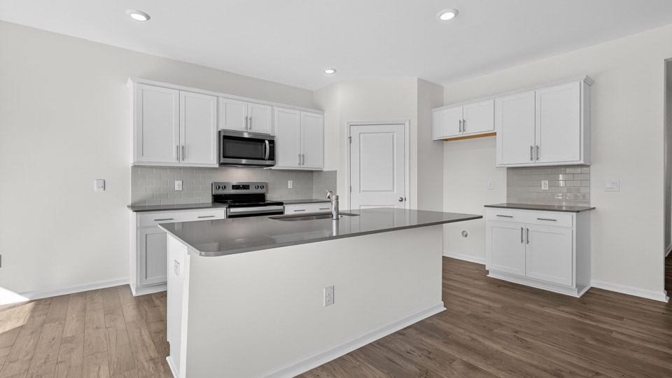 kitchen with quartz counters, kitchen island, pantry, stainless steel appliances