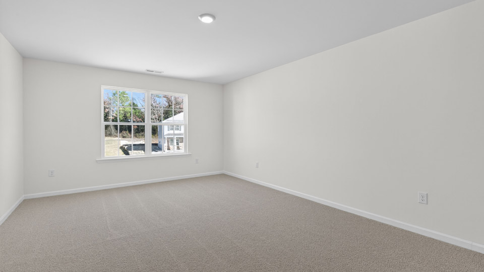 primary bedroom with two windows and carpeting, attached bath