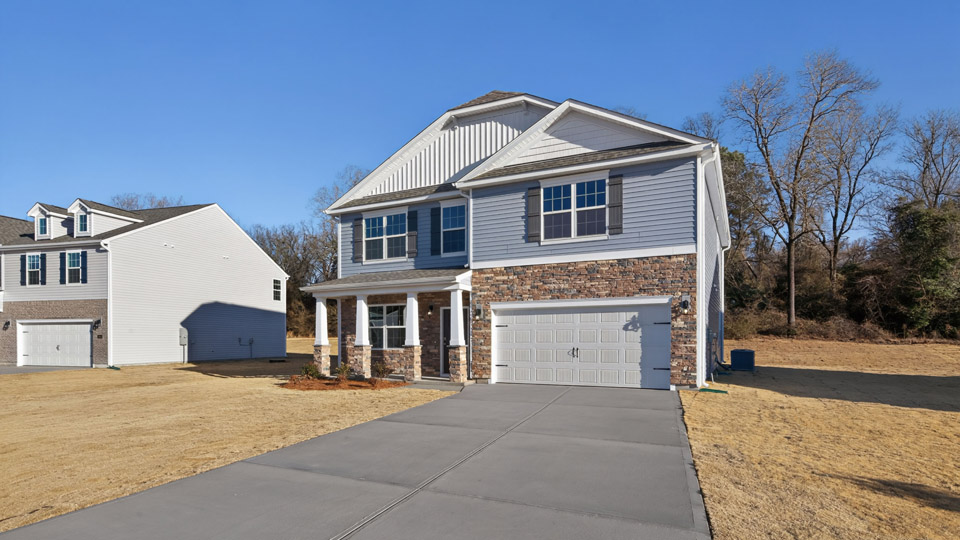Two story home with blue siding and a covered porch and two-car garage.