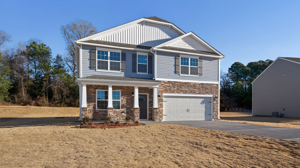 Two story home with blue siding and a covered porch and two-car garage.