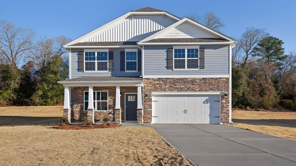 Two story home with blue siding and a covered porch and two-car garage.
