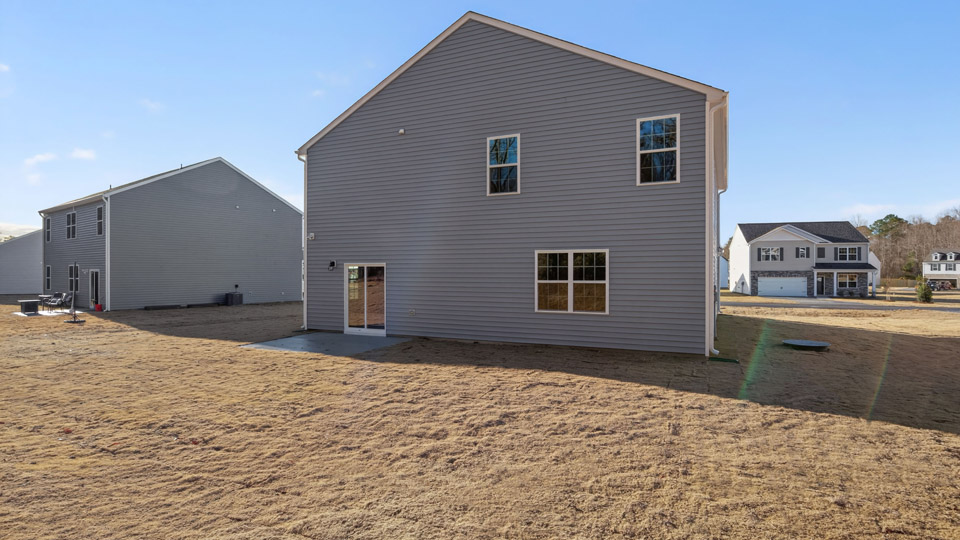 Two story home with blue siding and back patio