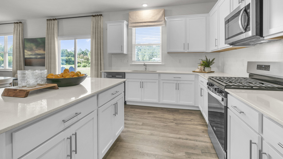kitchen with white cabinets and white quartz countertops and kitchen island