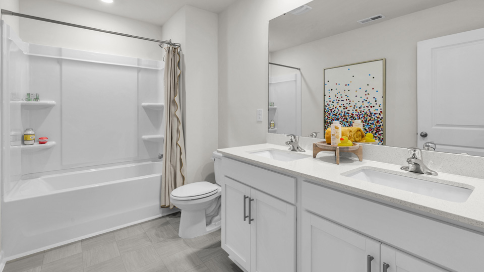 secondary bathroom with dual vanity and walkin tub shower combo