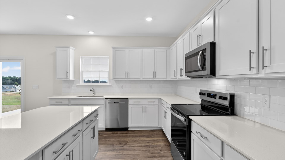 kitchen with quartz counters, kitchen island, pantry, stainless steel appliances