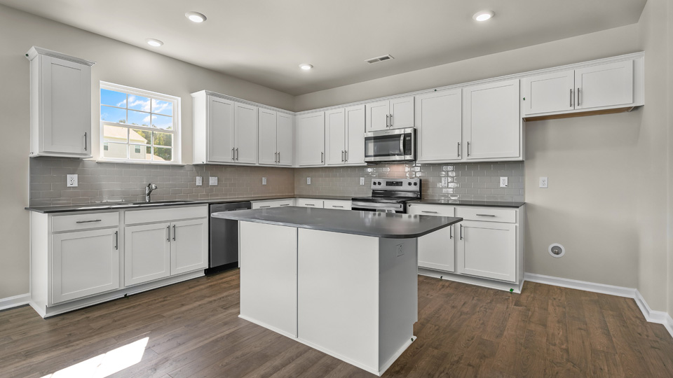 kitchen with quartz counters, kitchen island, pantry, stainless steel appliances