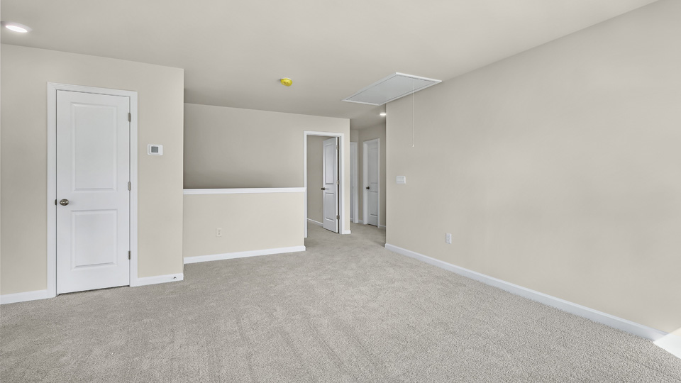 upstairs loft area with large windows and carpeting