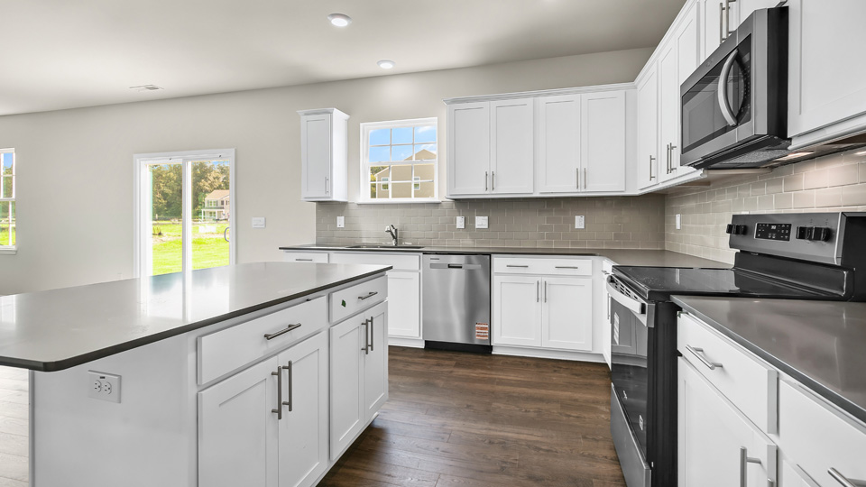kitchen with quartz counters, kitchen island, pantry, stainless steel appliances